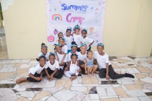 A group of young girls sitting on the ground.