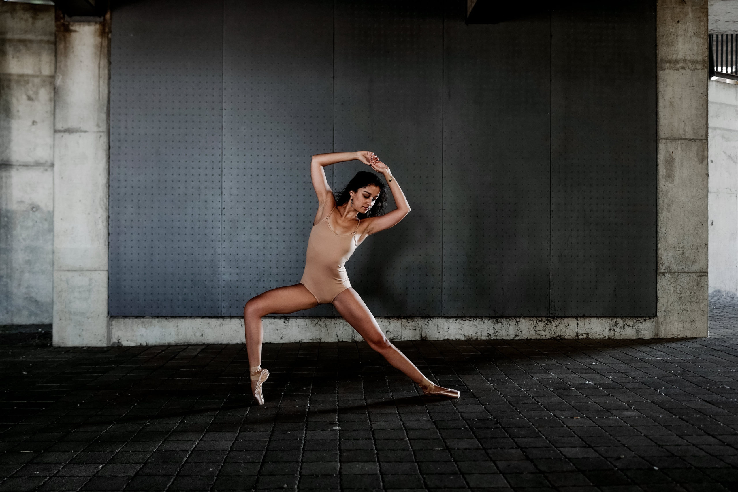 A woman in a nude body suit stretching