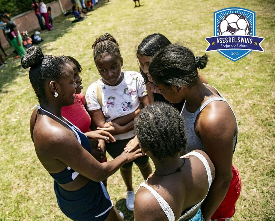 A group of young women standing around each other.