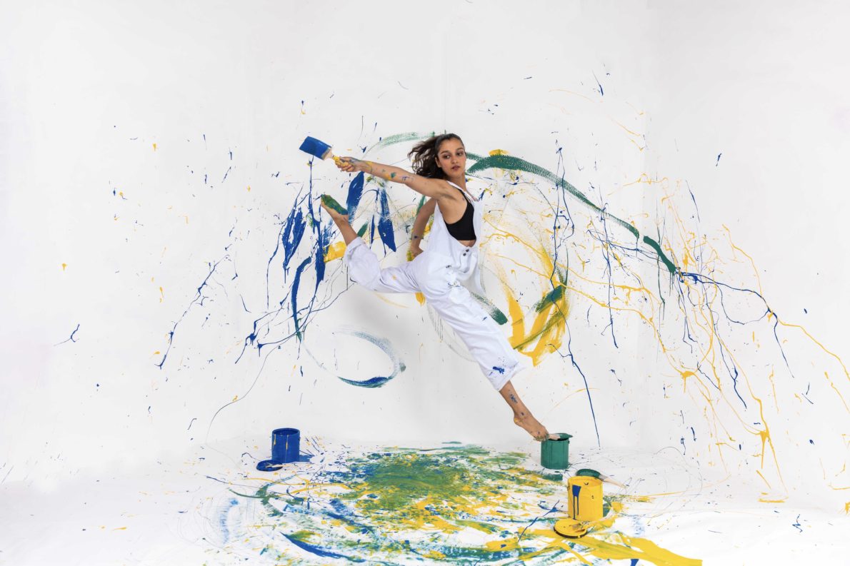A woman is jumping in the air with paint on it.