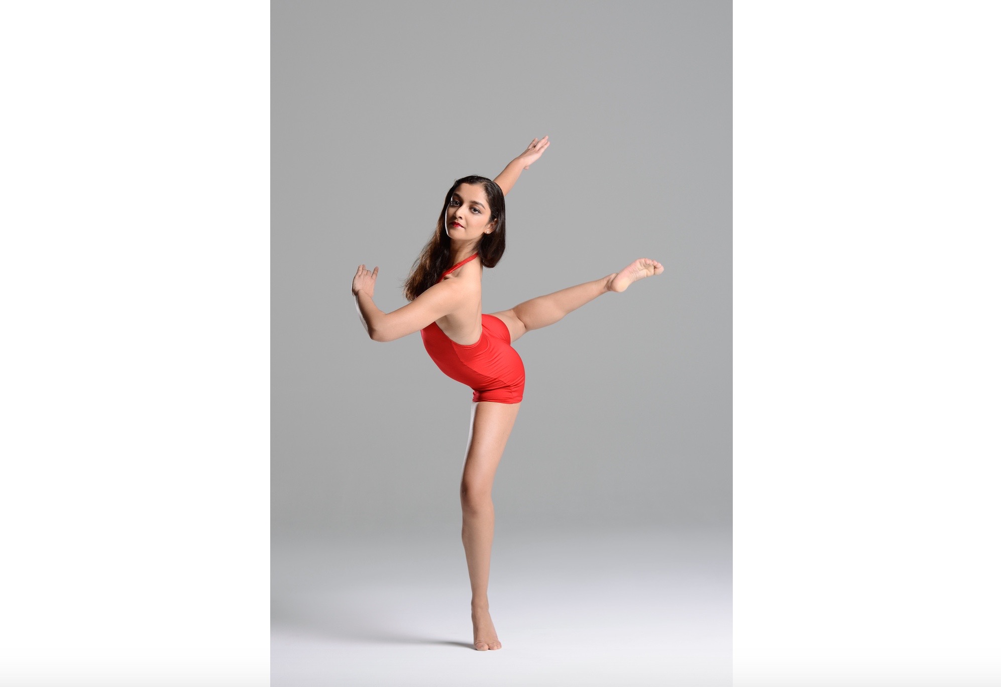 A woman in red leotard and black hair.