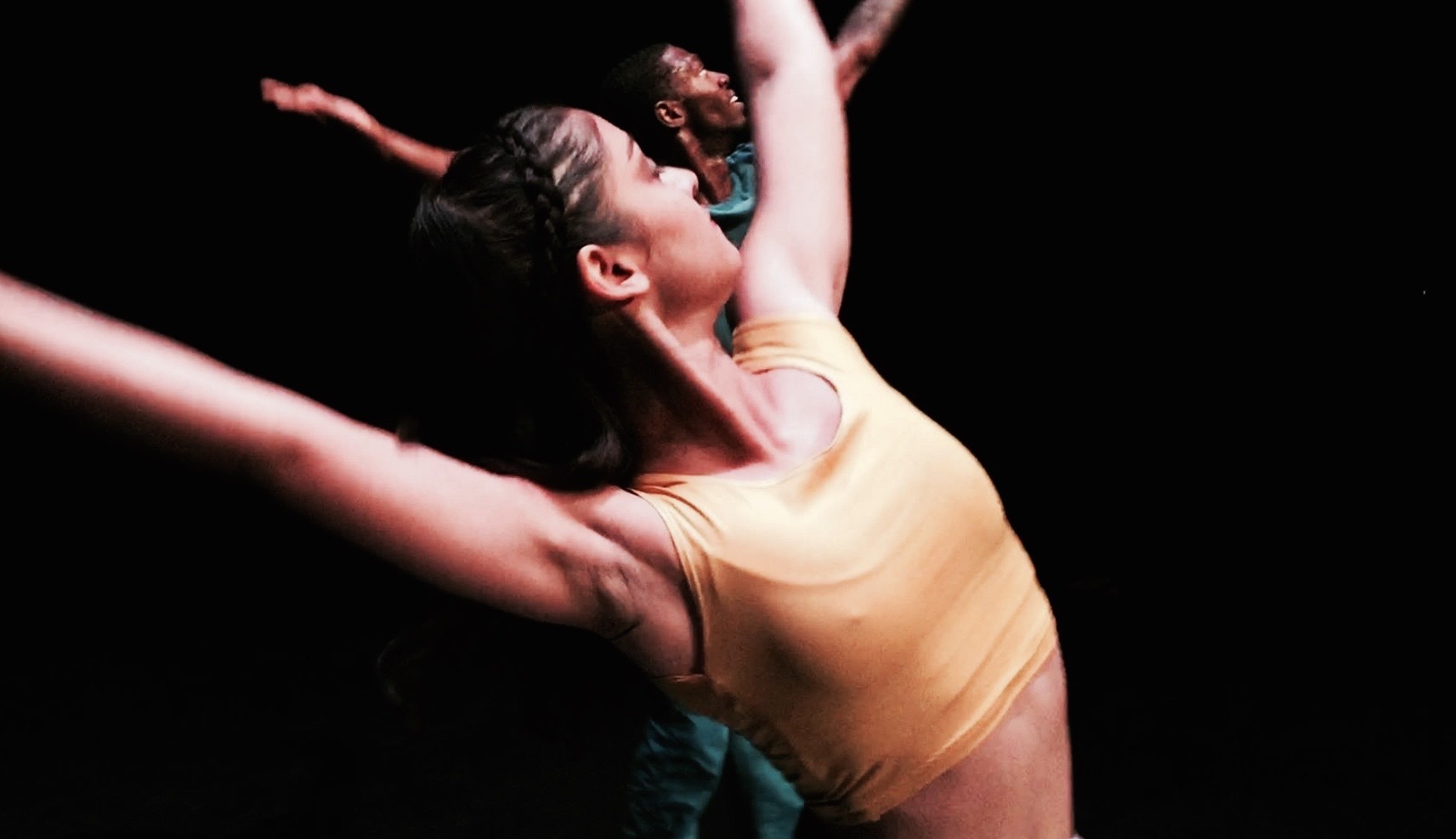 A woman in yellow shirt performing on stage.