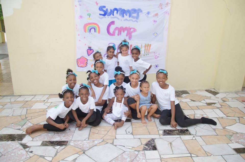 A group of young girls sitting on the floor.