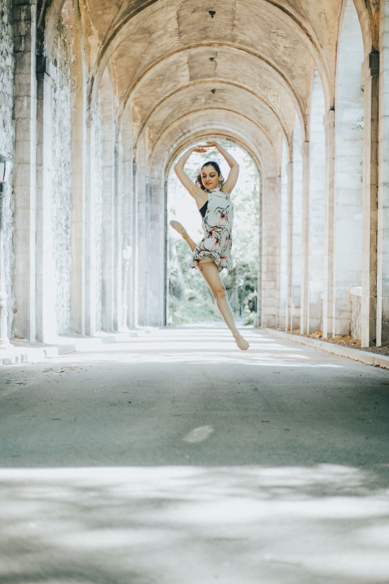 A woman jumping in the air with her arms outstretched.