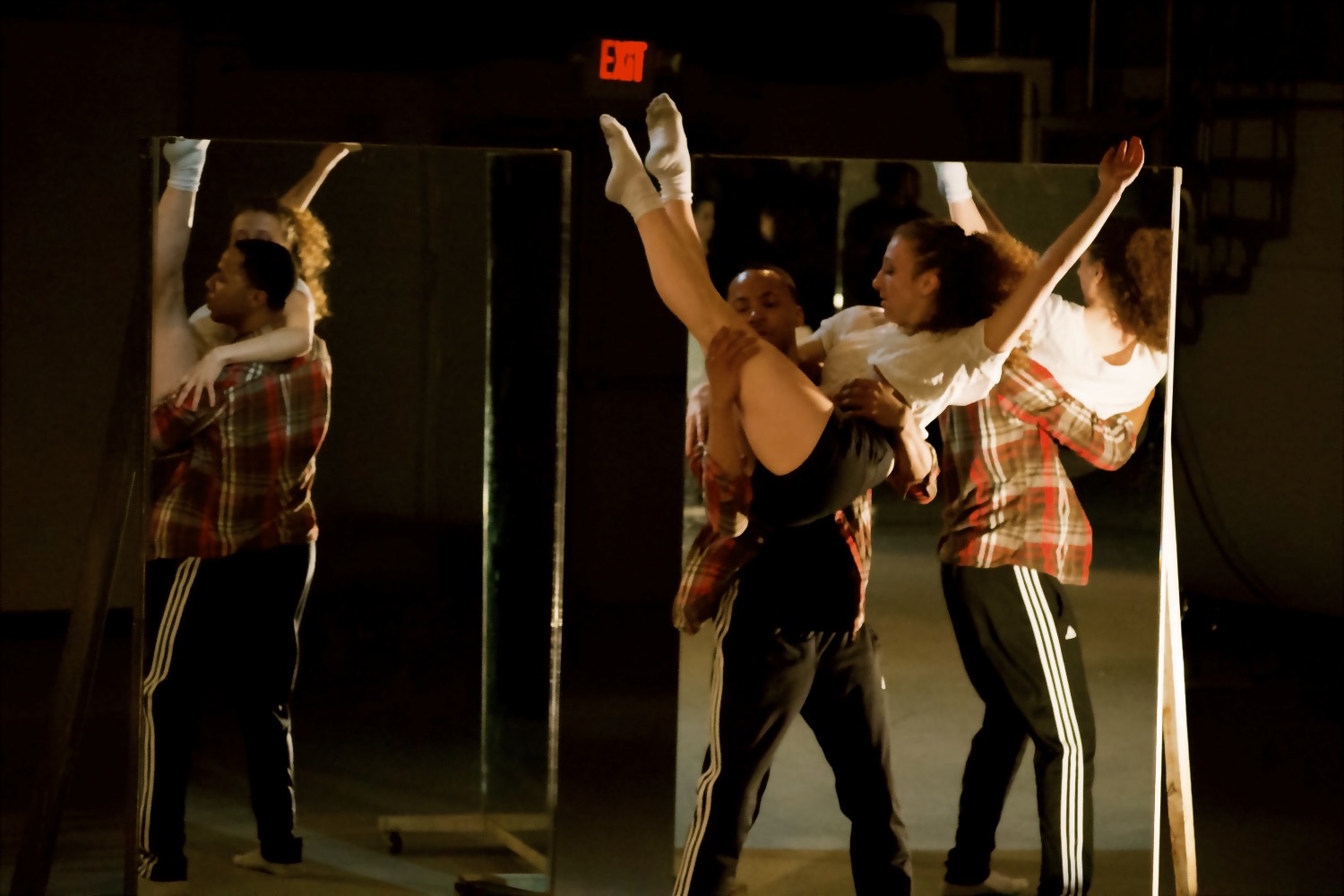 A group of people dancing in front of a mirror.