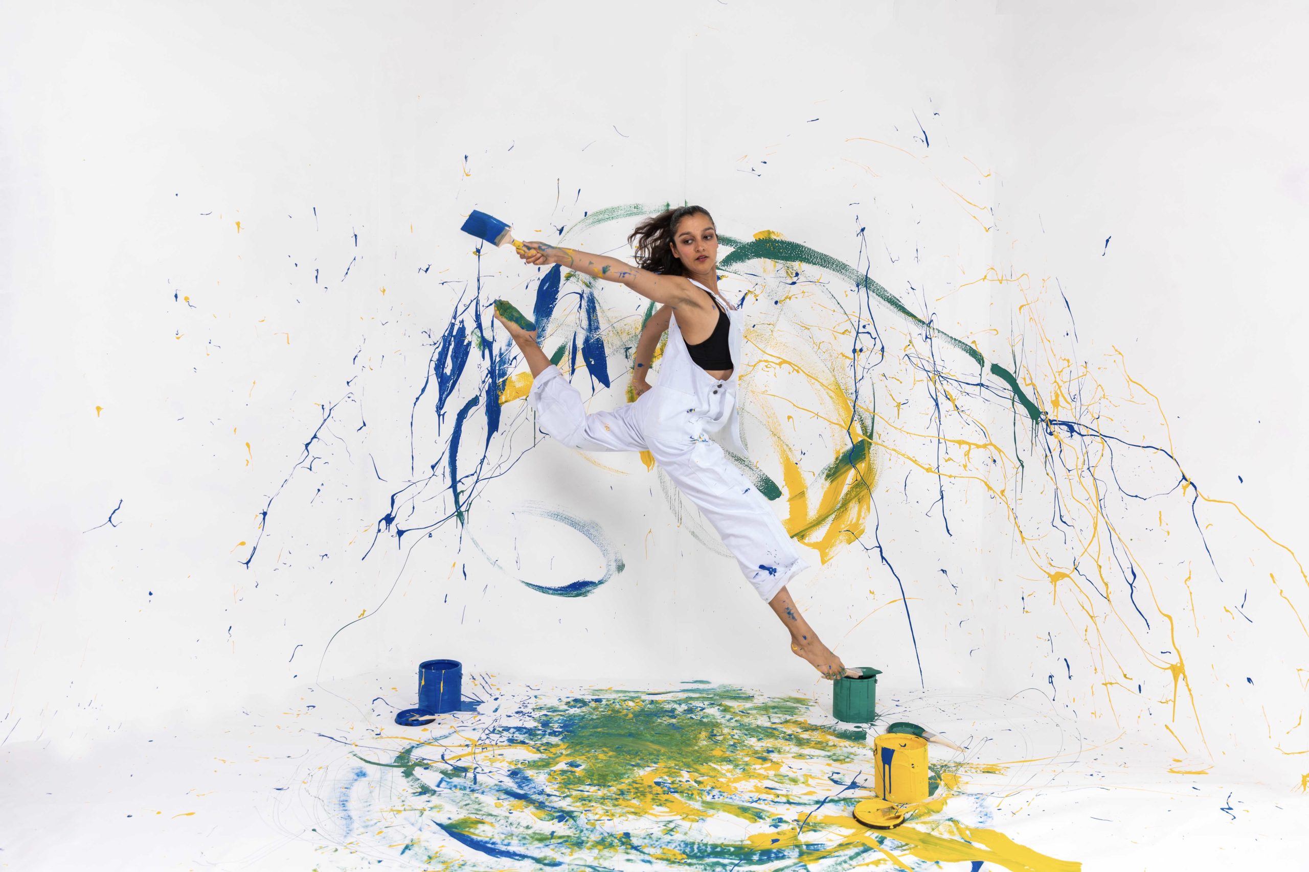 A woman is jumping in the air with paint on it.